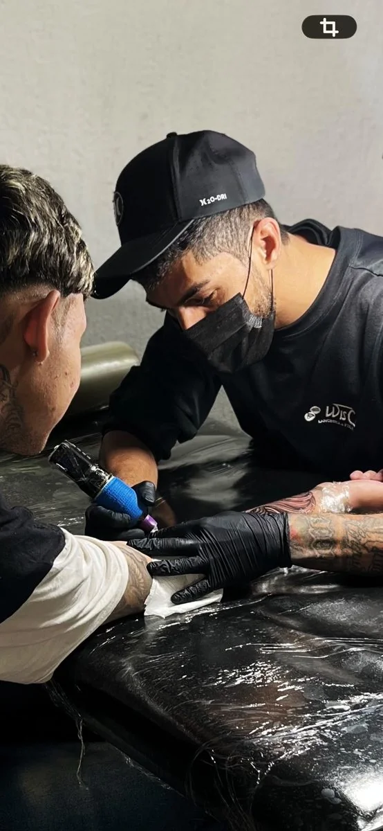 Maicon tatuando cliente